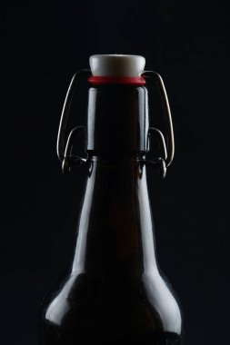beer bottle with lid dark glass on a dark background clipart