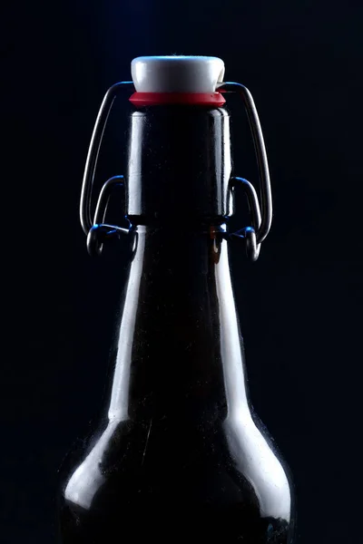 Siyah arka planda kapağı koyu camlı bira şişesi. — Stok fotoğraf