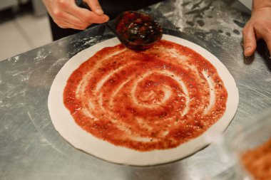 Mutfaktaki şef pizza hazırlıyor.