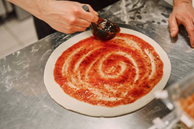 Mutfaktaki şef pizza hazırlıyor.