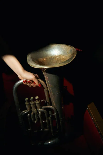 Trompete na mão em uma música de fundo preto — Fotografia de Stock