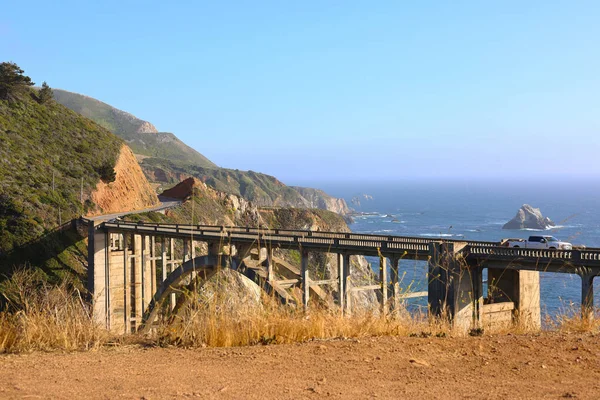 Bixby Creek Bridge Overlooking the Pacific Ocean Along Scenic Highway 1 in Big Sur, California, With Cars Driving Across the Iconic Landmark During a Coastal Road Trip Near Monterey