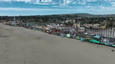 Santa Cruz, California, USA on January 10 2025: POV Aerial Drone Footage of Santa Cruz, the Boardwalk Amusement Park Captures Coastal Views, Roller Coaster Rides, Crowds and Arcade on a Gloomy Day
