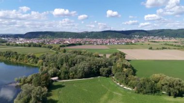 aerial panorama of river, forest, and farmland with town in the background on a clear summer day