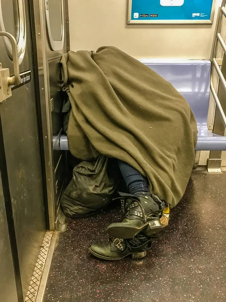 Manhattan, NY US - February 15, 2018 Homeless person sleeps in a subway car. — Stock Photo, Image
