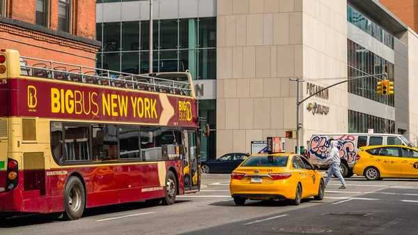 Manhattan, New York City US - April 10, 2019 street corner with a sightseeing tour bus and yellow taxi in Manhattan, NY. — Stock Photo, Image