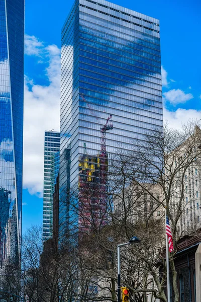 Seven World Trade Center avec nuages et grue de construction reflétés dans les fenêtres  . — Photo