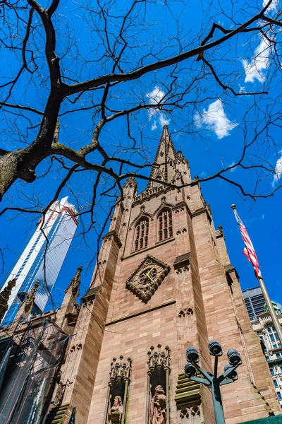 Frammento della chiesa di St. Pauls a Trinity Chiesa di Wall Street con bandiera americana, albero e grattacielo . — Foto Stock