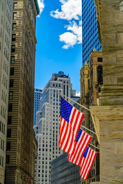 华尔街，太阳照亮了纽约金融区，曼哈顿，纽约，纽约的门面上的3面美国国旗 — 图库照片