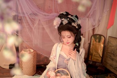 Antik Çin 'in zarafetini yaşayın. Bu zarif kadın, Hanfu elbisesi içinde, elinde bir çiçek sepeti, sonsuz bir güzellik ve dingin bir cazibe yayıyor.