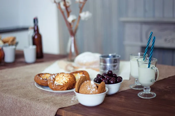 The perfect morning breakfast for the mum and her little son. Milk and buns with cream. Fantastic morning for two