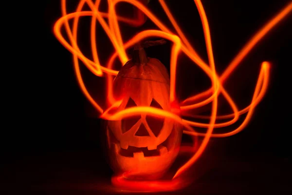 luminous pumpkins in the dark for the autumn Halloween holiday. Jack\'s grinning head. magical bright neon yellow and orange light in the darkness of Freezelight. All Saints\' Day