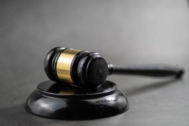 Hakimin ahşap tokmağının yakın plan, düşük açılı bir çekimi, altın bir bantla, grev bloğunda dinleniyor..