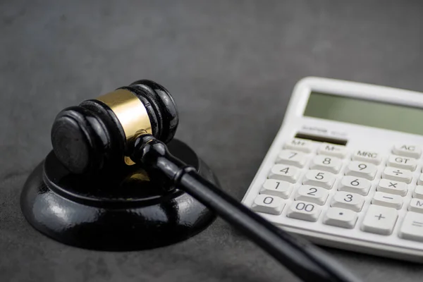 Hakimin ahşap tokmağının yakın plan, düşük açılı bir çekimi, altın bir bantla, grev bloğunda dinleniyor..