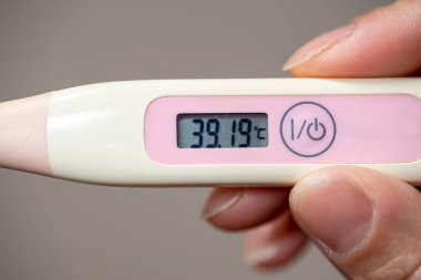 Dijital termometre, yüksek vücut ısısı, yüksek ateş, yüksek ateş, kendini izleme, sağlık ve tıbbi konsept ile evde sıcaklık kontrol ediliyor