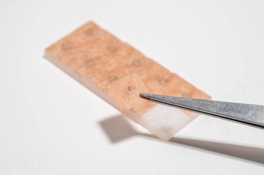 Geleneksel Çin ilaç tedavisinde kullanılan küçük bir baskı iğnesi (deri içi iğne) uygulamaya hazırlanan bir parmak.