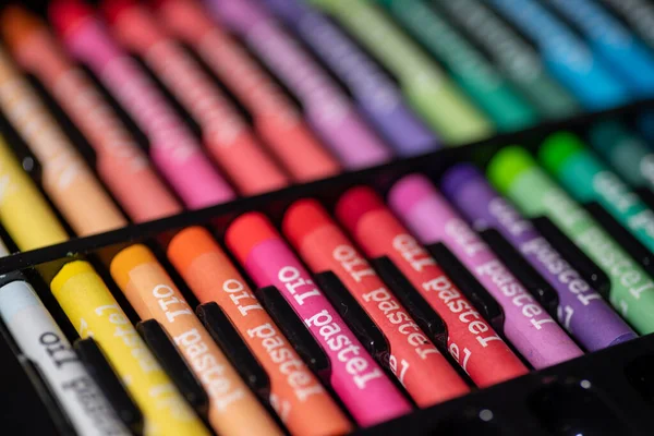 Altı yağlı boya pastel boya ya da pastel boyalardan oluşan bir yakın plan beyaz ızgaralı kağıt yüzeyinde gökkuşağı gradyanı..