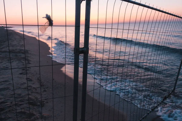 Sunsut deniz ya da okyanus mesh çit arkasında sahilde
