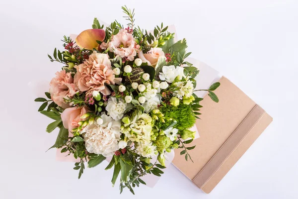 Düz beyaz arka plan üstünde defter ile güzel bir buket göklere