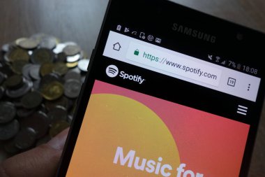 Konskie, Polonya - 14 Mayıs 2018: Samsung smartphone ve sikke yığını üzerinde görüntülenen Web sitesi Spotify