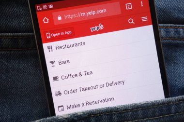 KONSKIE, POLAND - MAY 19, 2018: Yelp website displayed on smartphone hidden in jeans pocket clipart