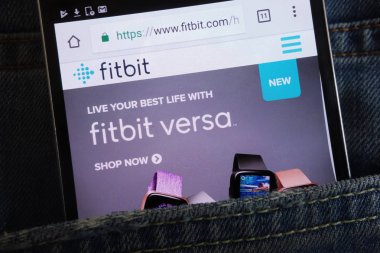 KONSKIE, POLAND - JUNE 02, 2018: Fitbit website displayed on smartphone hidden in jeans pocket clipart