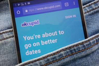 Konskie, Polonya - 08 Haziran 2018: kot pantolon cebinde gizli smartphone üzerinde görüntülenen Okcupid Web sitesi