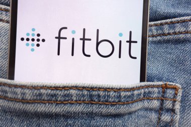 Konskie, Polonya - 12 Haziran 2018: kot pantolon cebinde gizli smartphone üzerinde görüntülenen Fitbit logosu