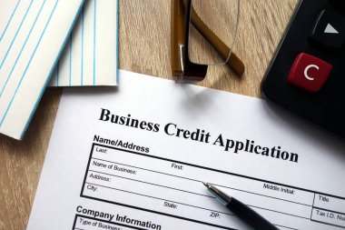 Kalem, hesap makinesi ve masa üzerine gözlük ile iş kredi başvuru formu
