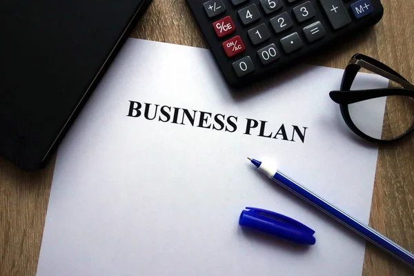 事業計画書 ペンや眼鏡の机の上の電卓 — ストック写真