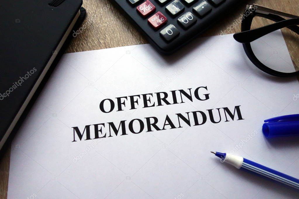 Offering memorandum document, pen, glasses and calculator on desk