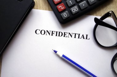 Gizli belge, hesap makinesi, kalem ve gözlük üstünde okul sırası