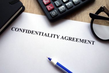 Confidentiality agreement, calculator, pen and glasses on desk clipart