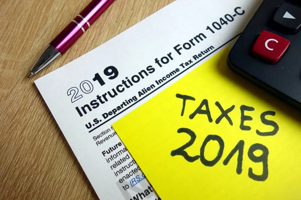 1040 计算器和笔在办公桌上的说明 税务季节2019年 — 图库照片