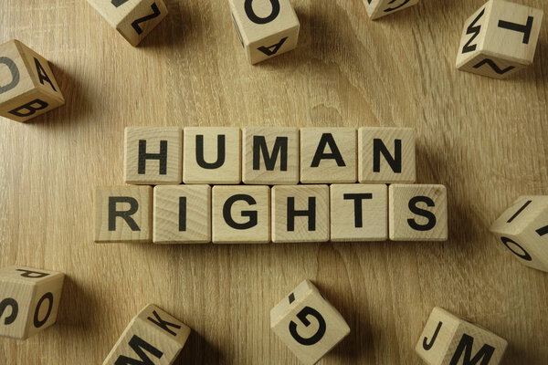 Human rights text from wooden blocks on desk