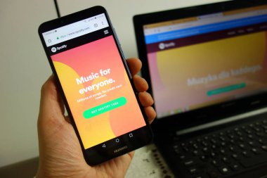 Konskie, Polonya - 08 Şubat 2019: Huawei smartphone cep telefonu ile Web sitesi arka plan üstünde laptop ile Spotify. Dijital aygıt kavramı kullanma