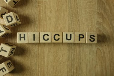 Hiccups word from wooden blocks on desk clipart