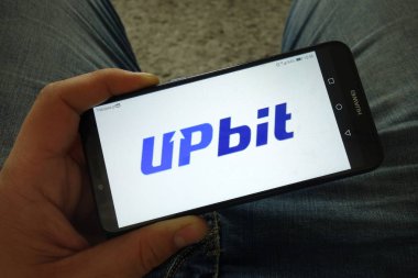Konskie, Polonya-31 Mart 2019: adam Upbit cryptocurrency Döviz logosu ile akıllı telefon tutan