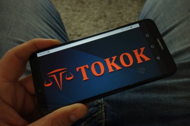 Konskie, Polonya-31 Mart 2019: tokok cryptocurrency Döviz logosu ile adam tutarak akıllı telefon