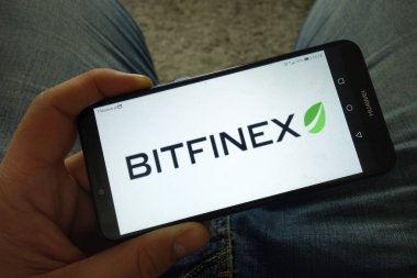 Konskie, Polonya-31 Mart 2019: Bitfinex cryptocurrency Döviz logosu ile adam tutan akıllı telefon