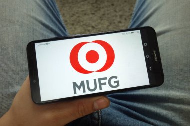 Konskie, Polonya - 13 Nisan 2019: Mitsubishi Ufj Financial Group, Inc. banka holding şirketi logosu ile akıllı telefon tutan adam
