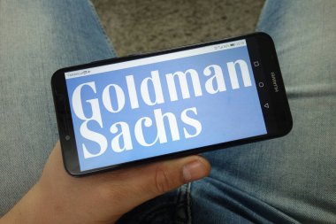 Konskie, Polonya - 13 Nisan 2019: Goldman Sachs şirket logolu akıllı telefon tutan adam