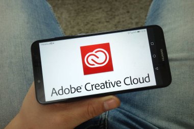 Konskie, Polonya - 13 Nisan 2019: Adobe Creative Cloud logolu akıllı telefon tutan adam