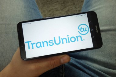 Konskie, Polonya - 13 Nisan 2019: Transunion Amerikan tüketici kredisi raporlama ajansı logosu ile akıllı telefon tutan adam
