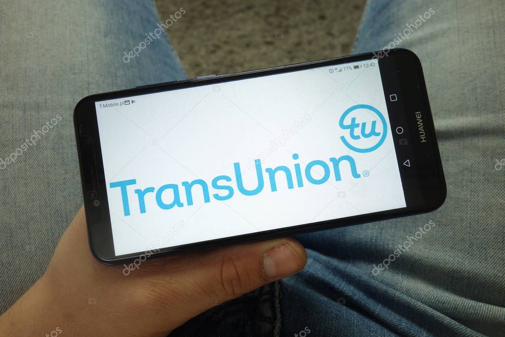 KONSKIE, POLAND - April 13, 2019: Man holding smartphone with TransUnion American consumer credit reporting agency logo