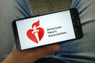Konskie, Polonya - 13 Nisan 2019: American Heart Association (Aha) logolu akıllı telefon tutan adam