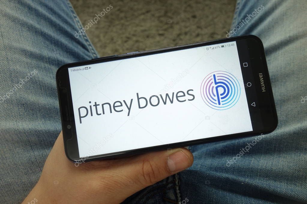 KONSKIE, POLAND - April 13, 2019: Man holding smartphone with Pitney Bowes company logo