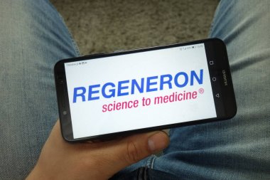 Konskie, Polonya - 13 Nisan 2019: Regeneron Pharmaceuticals, Inc. şirket logosuna sahip akıllı telefon tutan adam