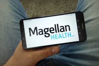 Konskie, Polonya - 13 Nisan 2019: Magellan Sağlık şirketi logolu akıllı telefon tutan adam