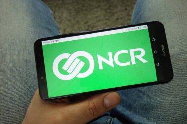 Konskie, Polonya - 13 Nisan 2019: Ncr Corporation logolu akıllı telefon tutan adam